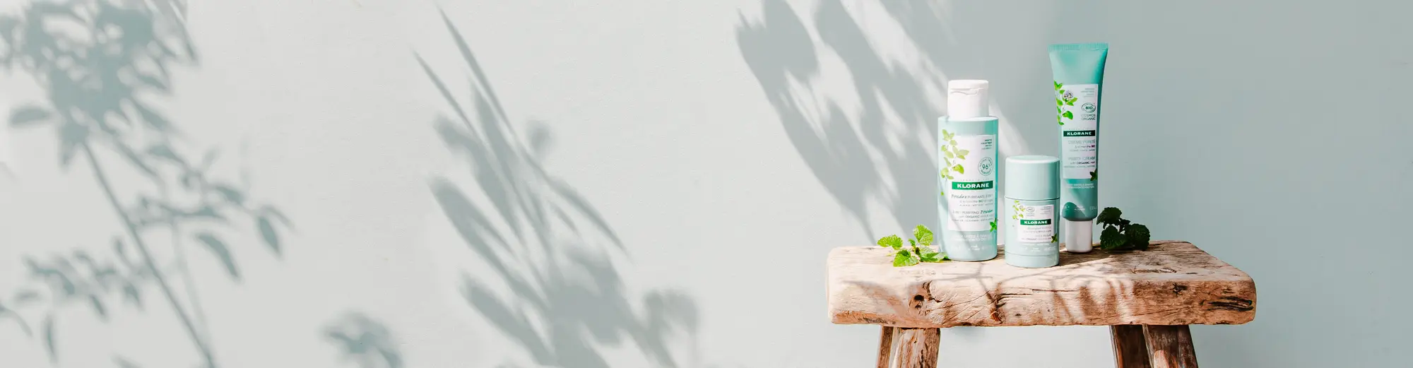 Productos de klorane encima de un banco de madera