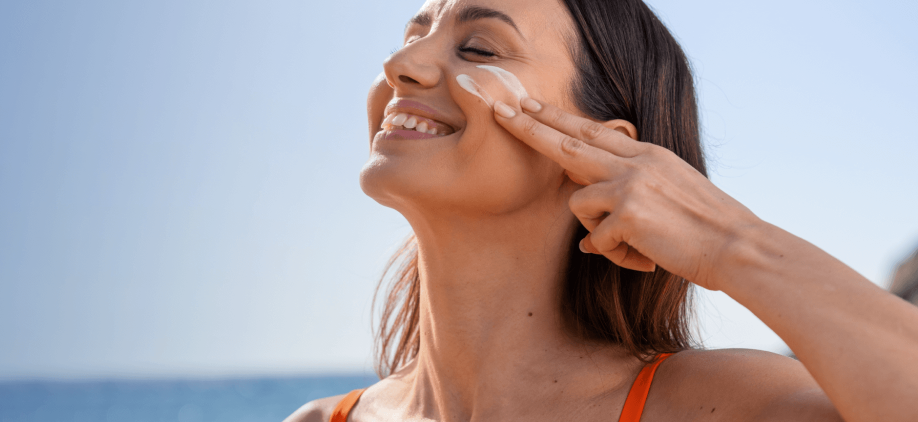 Mujer untándose crema en su cara